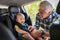 Man fasten seat belt for cute toddler