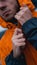 A man fastens his work uniform. Orange worker uniform - close up