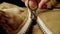 A man fastens a metal zipper on a beige jacket in macro. Extreme close up zipper with hand fastens clothing, while