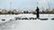 Man feeding big flock of pigeons in park in winter