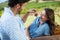 Man feeding grapes to cheerful partner