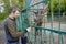 Man feeds deer grass at the zoo from his hands.