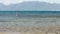 Man figure standing on knees rows paddleboard in ocean