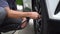 Man filling air in the tires of car inflating tire