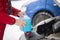 Man filling antifreeze coolant for cleaning front window with snow in background.