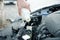 Man filling car radiator with antifreeze outdoors, closeup