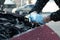 Man filling car radiator with antifreeze outdoors, closeup