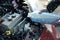 Man filling car radiator with antifreeze outdoors, closeup