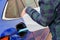 Man filling a diesel engine fluid from canister into the tank of blue car. Diesel exhaust fluid for reduction of air