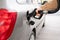 man filling fuel tank of his car with diesel fuel at the gas station close up, as cost of fuel going up