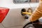 Man filling fuel tank of his car with diesel fuel off the jerry can as there is no fuel at the petrol station, close up