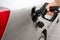 man filling fuel tank of his car with diesel fuel at the petrol station close up, as cost of fuel going up