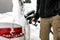 Man filling his snow covered diesel car gas tank at the fuel pump, detail on hand and gasoline nozzle