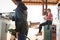 Man filling petrol in car while woman sitting at petrol pump station