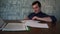 a man fills out paper while sitting at a table in defocus