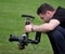 Man filming action professionally at agricultural show demonstration.