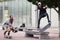 A man filming a skateboarder doing a flip on a bench