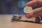 A man finger holding a coin with coin stack on bokeh background