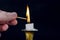 Man finger with Matchstick start light flame on candle in candlestick