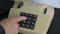 Man finger pressing numbers buttons on classic retro phone telephone