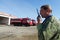 A man firefighter with a walkie-talkie in the background of special fire vehicles transmits an alarm signal