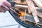 A man fires firewood for lighting in the barbecue grill. Grill for frying steaks in the backyard of the house. Family pastime.