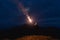 The man with a firework stick standing on a mountain.