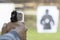 Man Firing Pistol at Target in Shooting Range