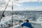 A man in a fishing boat in a stormy ocean with a view of the coast of Miami.