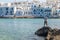 Man fishing on the city waterfront.Naoussa, Paros Island, Greece