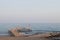 A man is fishing with a fishing rod near a rocky shore. Fisherman on the beach in Alanya. Fishman stands on the rocks in