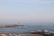 A man is fishing with a fishing rod near a rocky shore. Fisherman on the beach in Alanya. Fishman stands on the rocks in