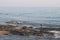 A man is fishing with a fishing rod near a rocky shore. Fisherman on the beach in Alanya. Fishman stands on the rocks in