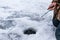 A man is fishing in the ice-hole in winter