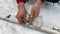 A man fixes a binding on a touring ski. Close-up of hands. Ski trip in the forests of Russia.