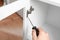 Man fixing door angle hinge of wooden cabinet