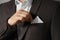 Man fixing handkerchief in breast pocket of his suit, closeup