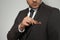 Man fixing handkerchief in breast pocket of his suit on light background, closeup