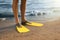 Man in flippers on sandy beach, closeup