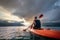 Man floating on kayak in the morning under sunrise sky on Cheow Lan Lake, Khao Sok national park, Thailand