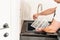 A man flushes the air cleaner filter from the air conditioner.