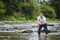 Man fly fishing casts on Irish river