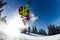 A man flying through the air while riding a snowboard down a snowy hill