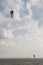 A man flying with a kite surf on a lake, with a deep, cloudy sky