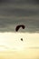 Man flying a paraglider against the clouds