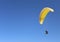 Man flying on a paraglider on the blue sky background