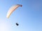 Man flying on a paraglider on the blue sky background