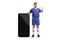 Man in a football jersey standing next to a big smartphone and showing thumbs up