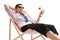 Man in formal clothes with a cocktail relaxing in a deck chair