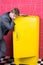 Man formal elegant suit stand near retro vintage yellow refrigerator. Vintage household appliances. Bachelor hungry